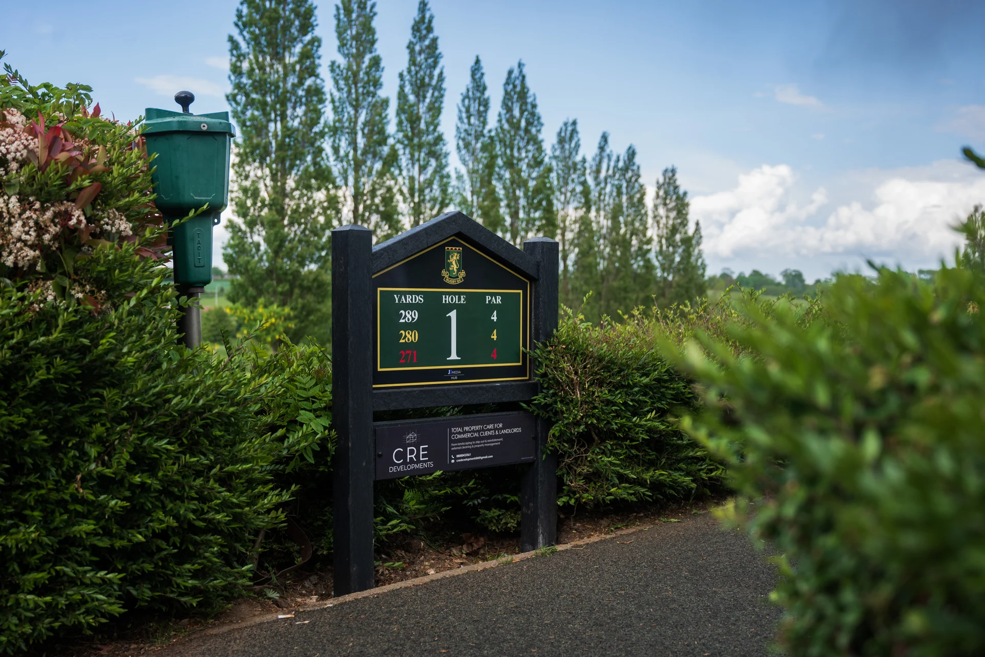 Rugby Golf Club first tee sign and sponsor panel in its landscaped setting